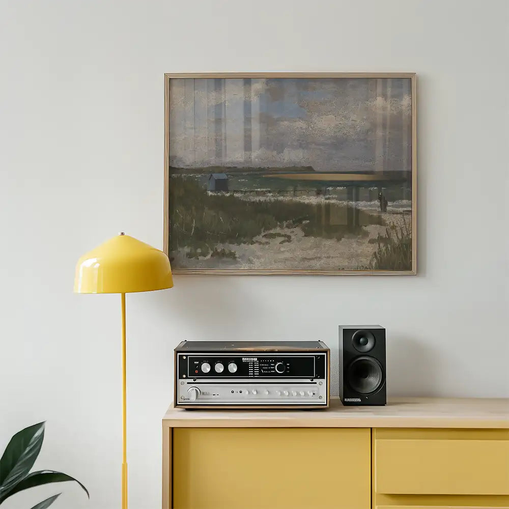 Painting of a serene beach landscape framed on a wall, with a yellow lamp and a vintage speaker positioned on a wooden cabinet.