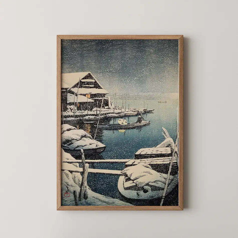 Framed painting of a snowy harbor scene with boats and a small building, depicting a serene winter landscape.