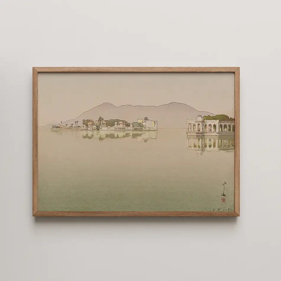 Framed painting of a serene landscape featuring buildings along a calm body of water with mountains in the background.