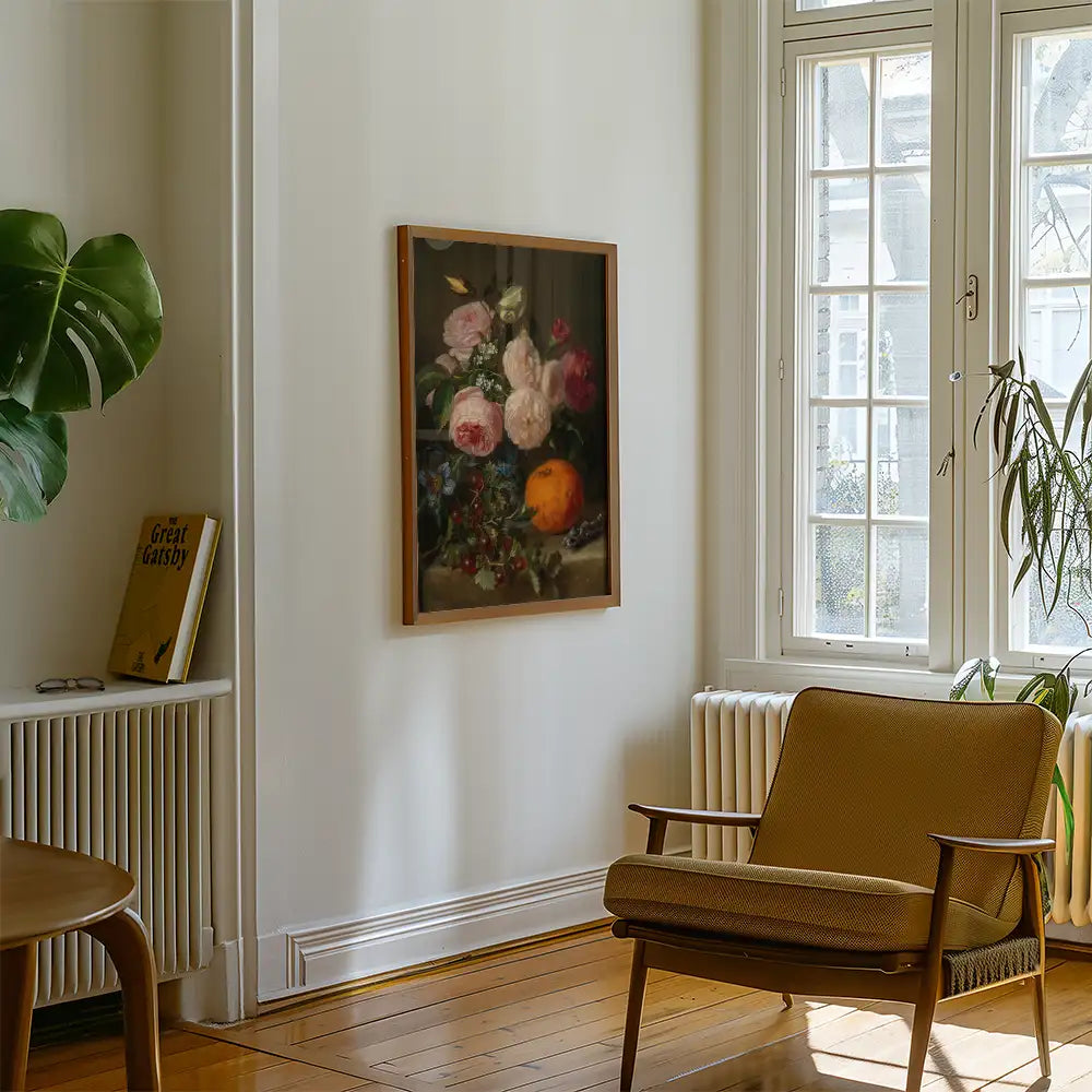 Floral painting hanging on a wall beside a cozy chair and a potted plant in a bright room.