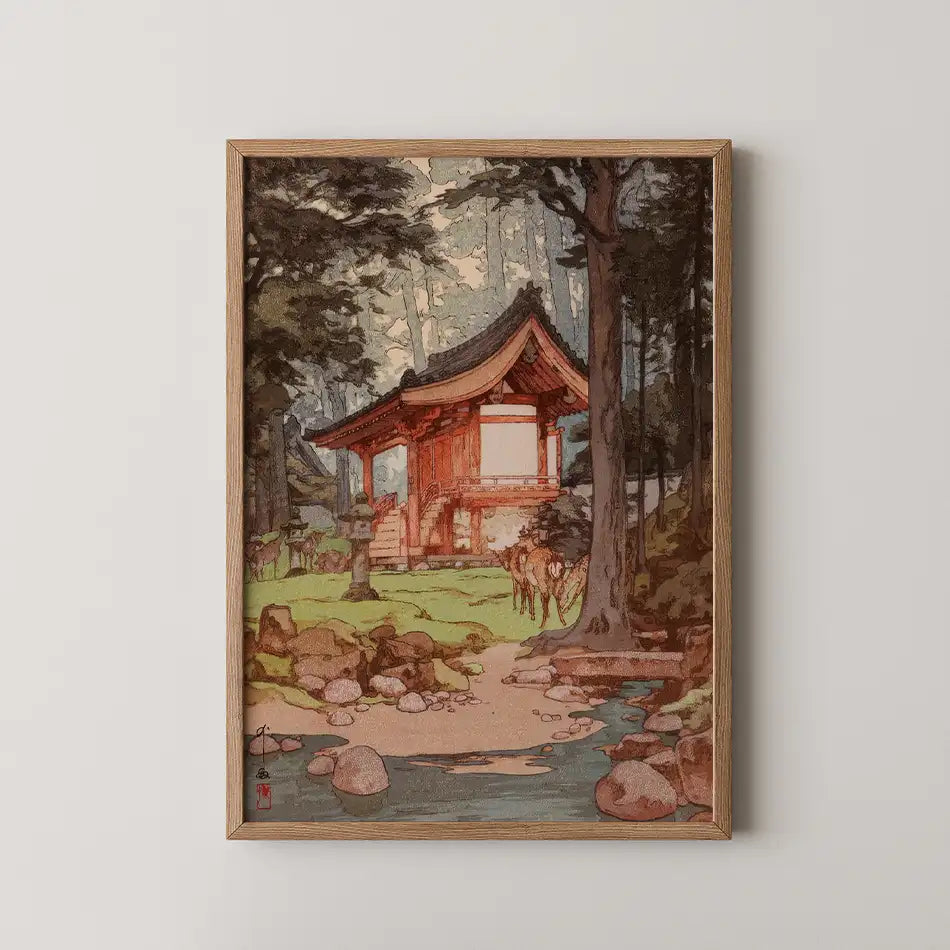 A framed painting of a traditional Japanese-style wooden house surrounded by trees and a serene stream with rocks in the foreground.