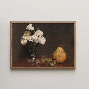 Still life painting featuring a vase of white roses, a yellow pear, and green grapes, framed in light wood.