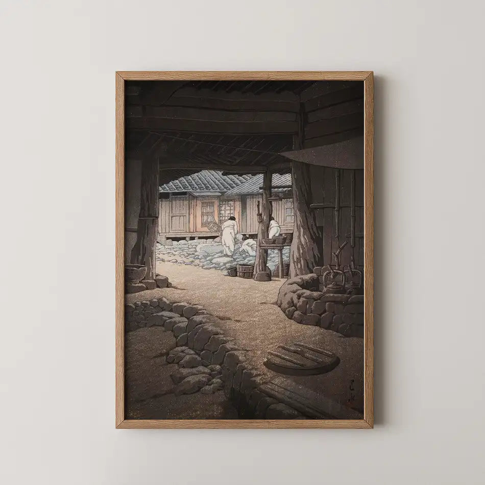 Framed painting depicting two figures in traditional attire working in a rustic outdoor setting with wooden structures and stone pathways.