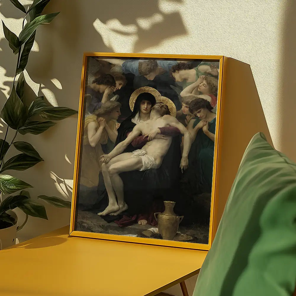 Painting of a mourning figure surrounded by others, depicting an emotional scene, framed in a yellow frame on a table with a green cushion and plant in the background.