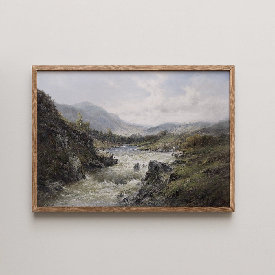 Framed landscape painting of a river flowing through rolling hills and mountains under a cloudy sky.
