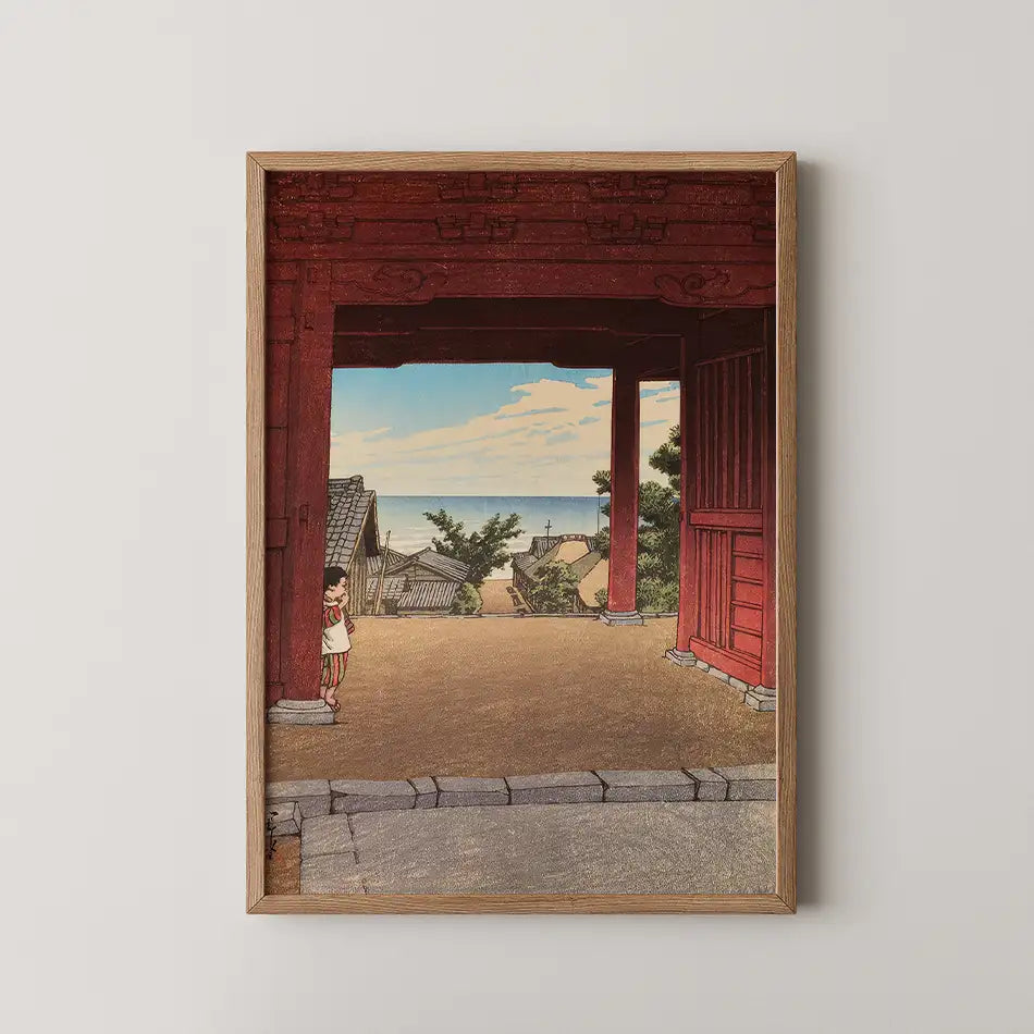 Framed painting of a coastal landscape featuring a child standing under a red archway, with a view of houses and the sea in the background.