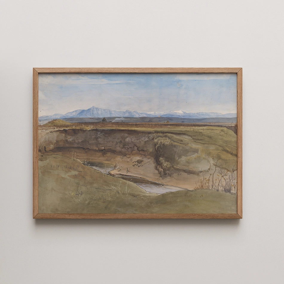 Framed watercolor painting of a landscape featuring rolling hills, a river, and distant mountains under a blue sky.