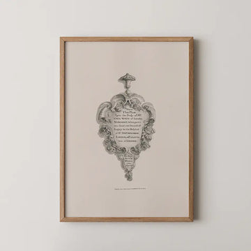 Framed vintage-style artwork featuring an ornate design with written text about John Want of London, displayed against a neutral background.