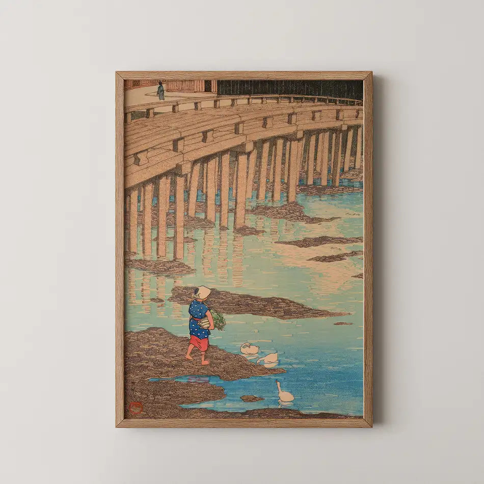 Vintage painting of a woman in a blue dress walking by a river, with a wooden bridge in the background and ducks in the water, framed in wood.