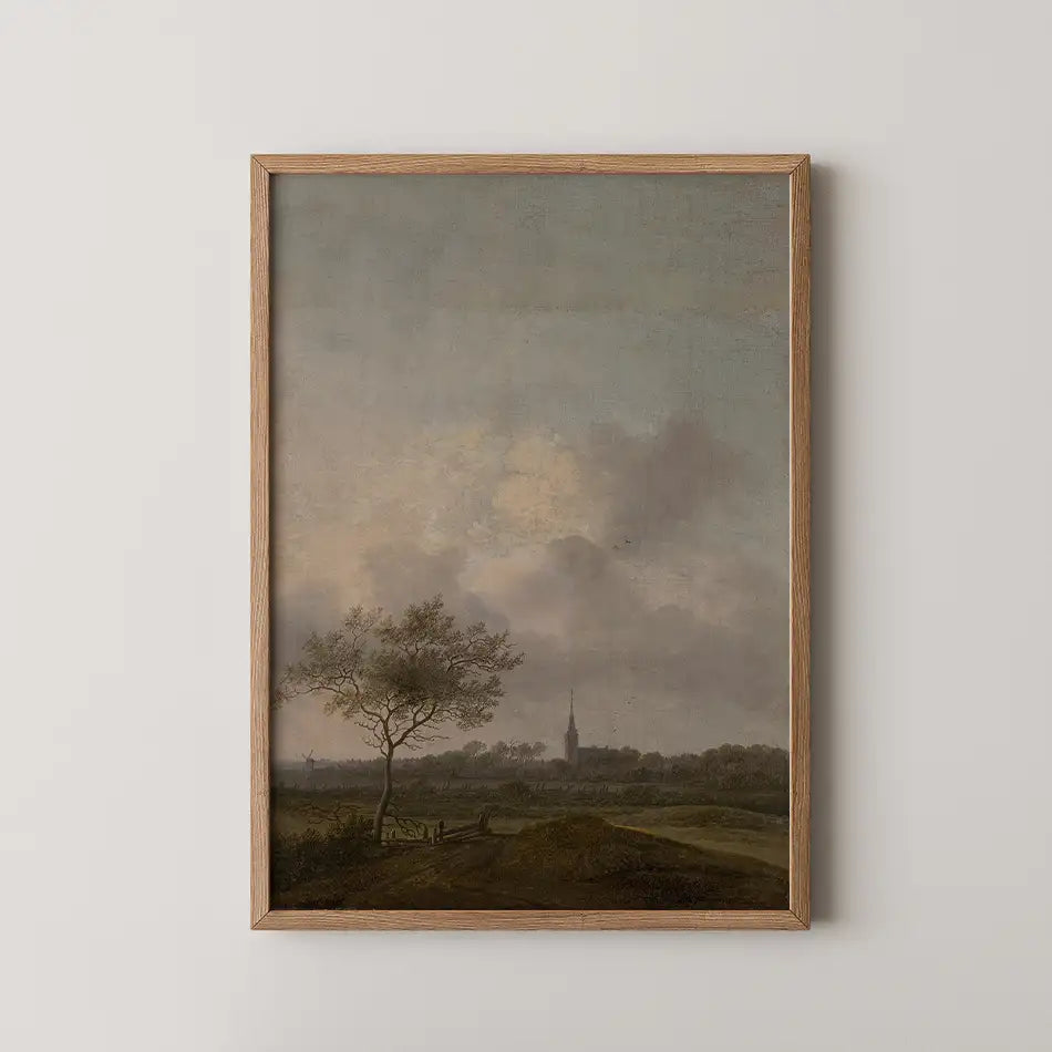 Framed painting of a serene landscape featuring a tree, rolling hills, and a distant steeple under a cloudy sky.