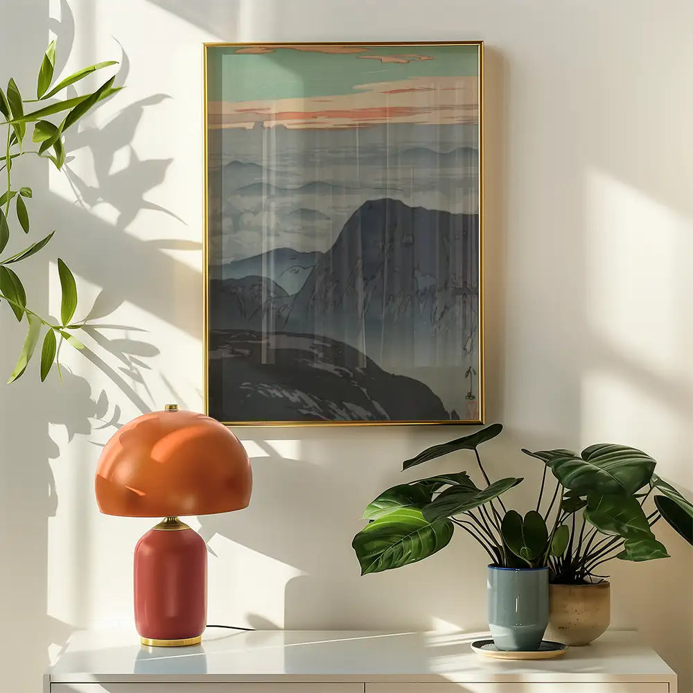 Framed mountain landscape painting on a wall with a modern lamp and indoor plants.