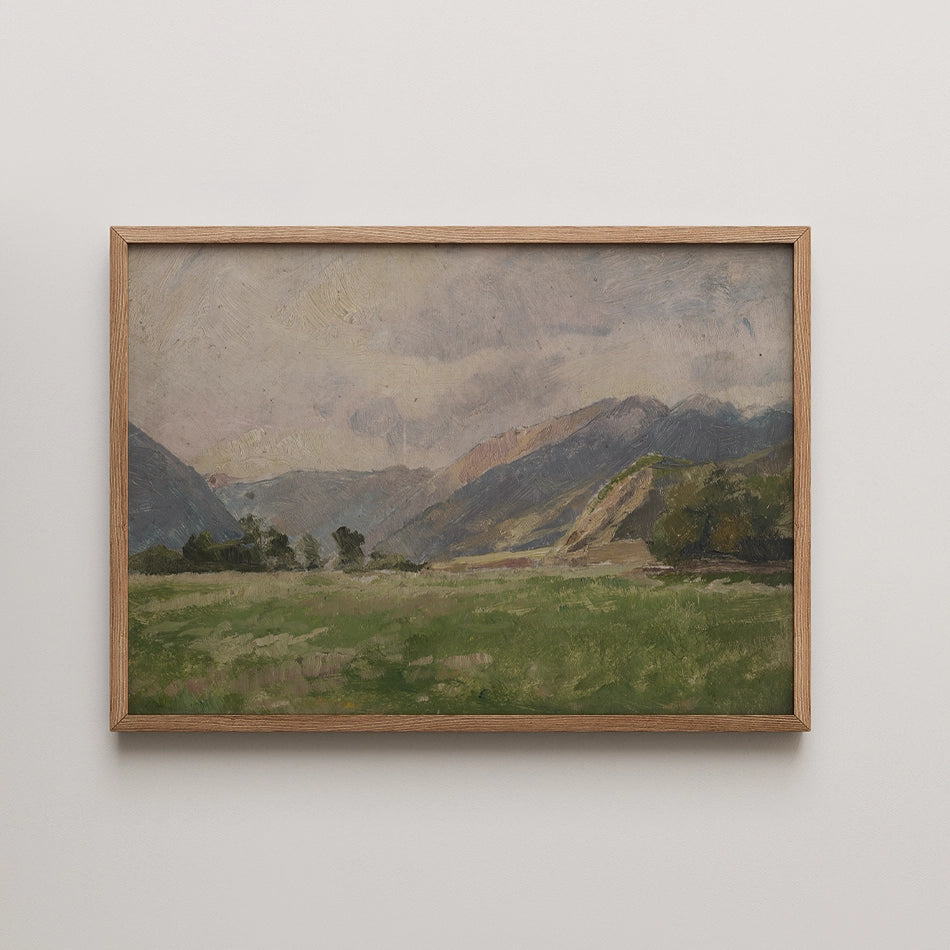 Framed painting of a serene landscape featuring rolling hills and a cloudy sky.