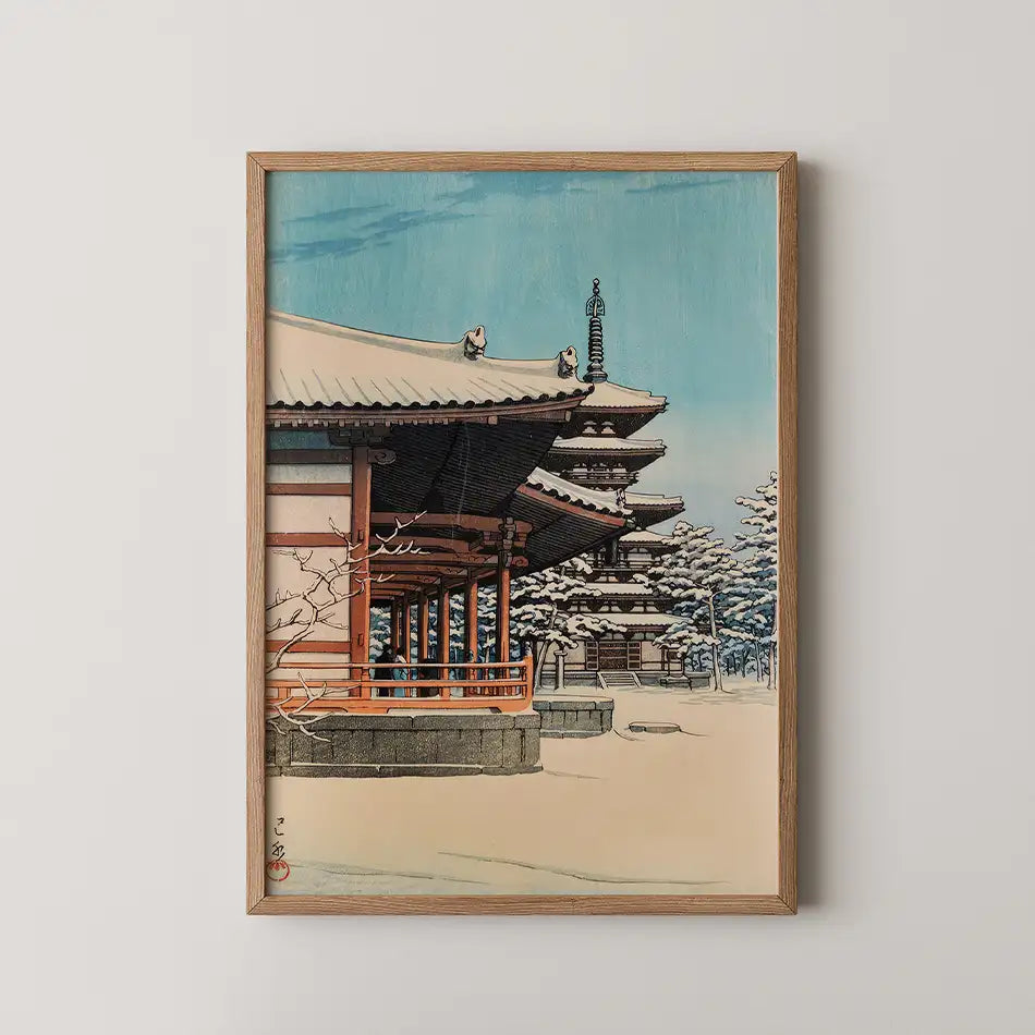 Framed painting of a traditional Asian building surrounded by snow-covered trees under a blue sky.