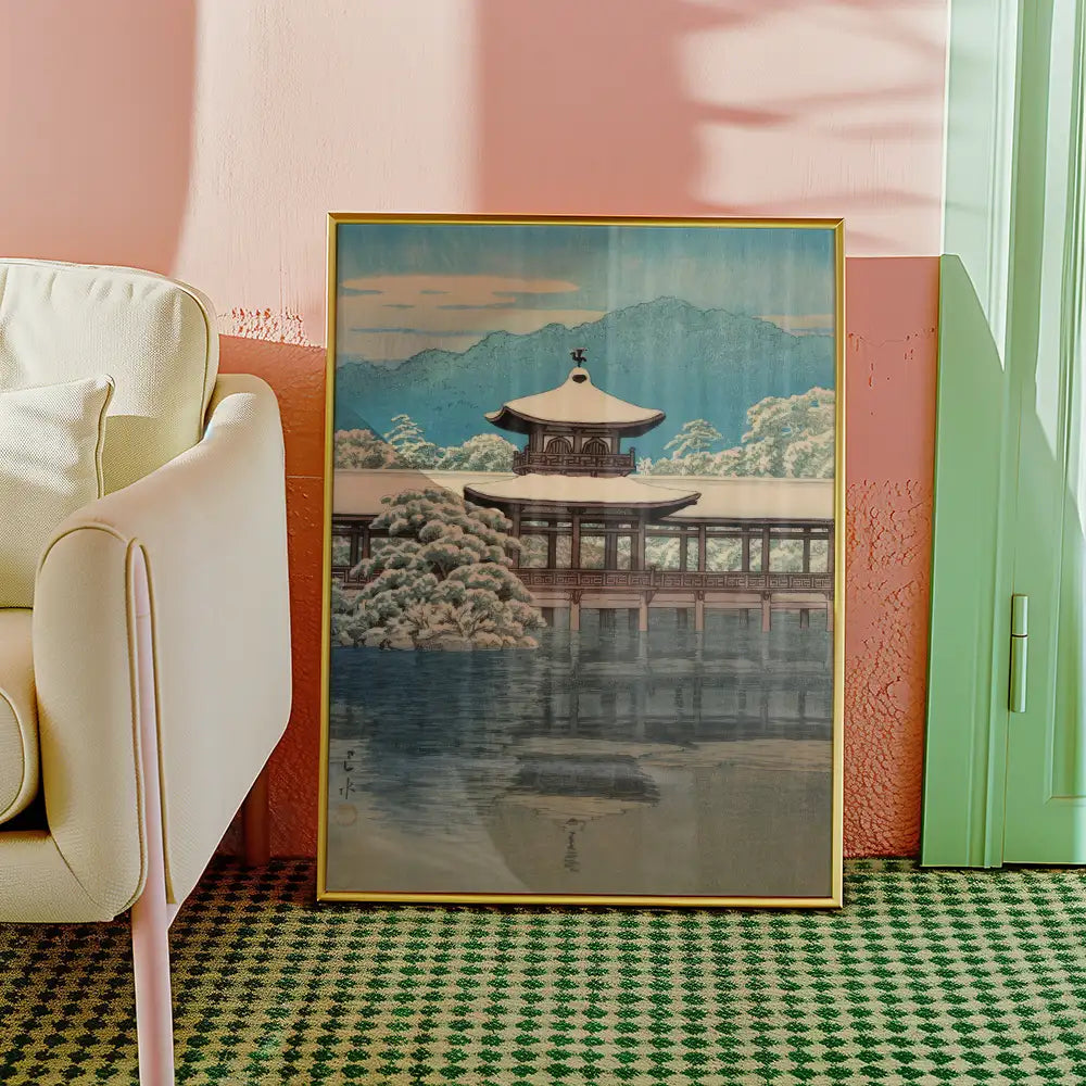 Framed painting of a serene landscape featuring a traditional pagoda surrounded by snow-covered trees and mountains in the background, displayed in a modern interior setting.