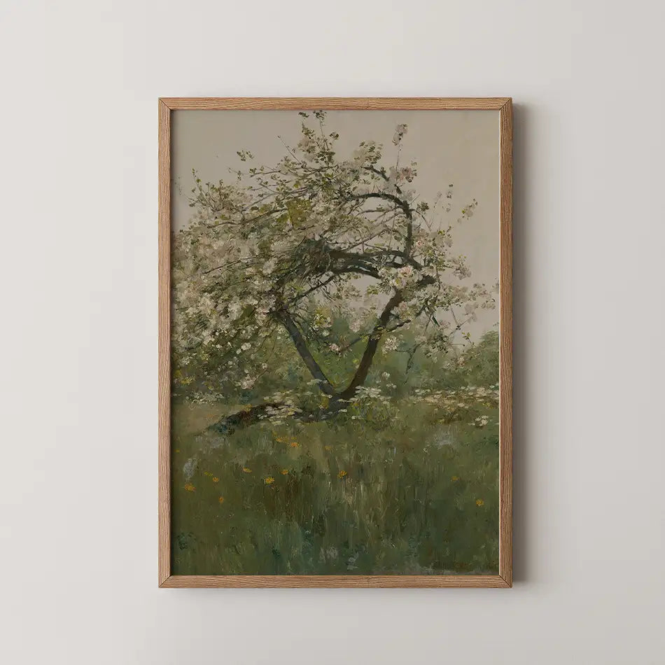 Framed painting of a flowering tree in a green field with soft colors.