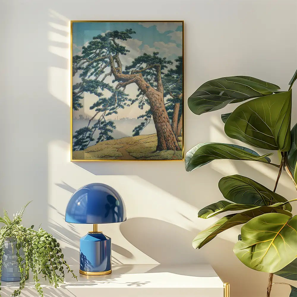 Framed painting of a scenic landscape featuring tall trees and a pathway, displayed on a wall beside a modern blue lamp and indoor plants.