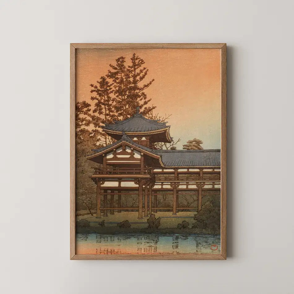 Framed painting of a traditional Japanese building beside a calm water body at sunset.