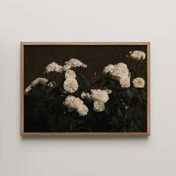 White floral painting in a wooden frame against a dark background.