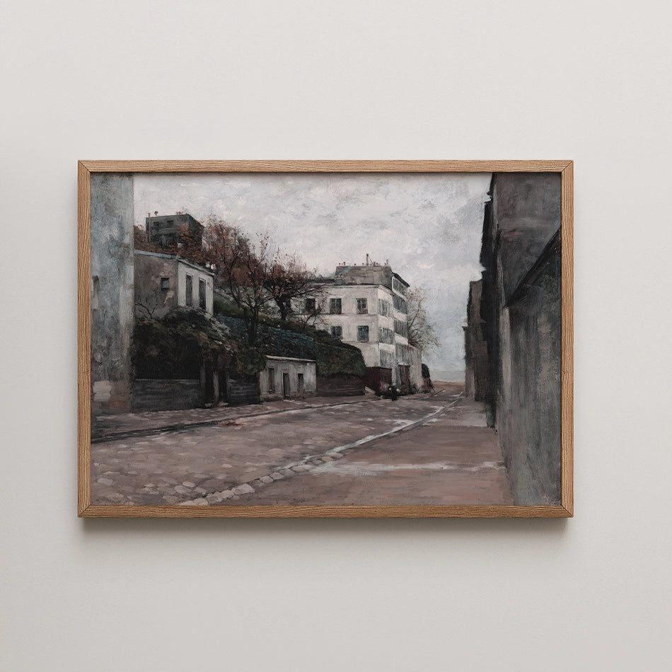 Framed painting of a quiet urban street scene with buildings and trees under a cloudy sky.