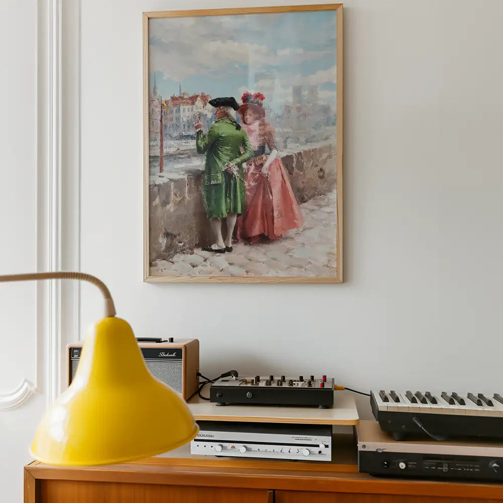 Painting of a man in a green coat and a woman in a pink dress standing by a waterfront, framed and hung on a wall, with a yellow lamp and music equipment in the foreground.