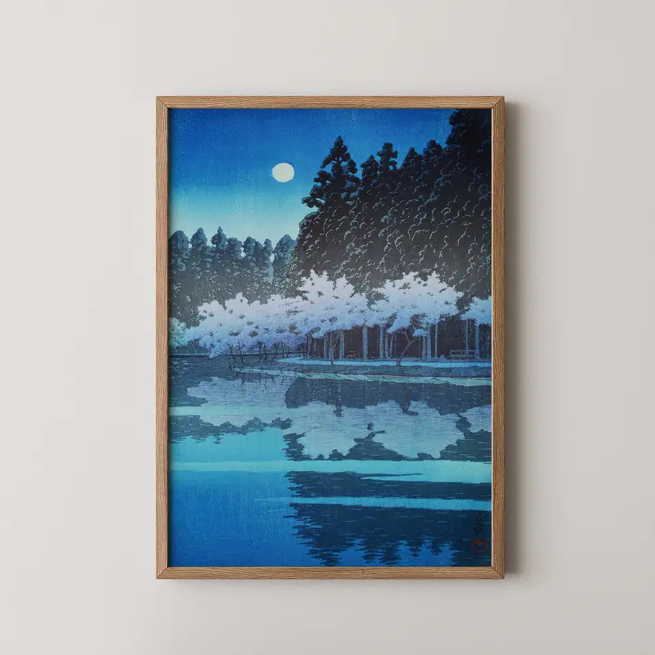 A framed painting of a tranquil night scene featuring trees and a moon reflecting on a calm body of water, predominantly in shades of blue.