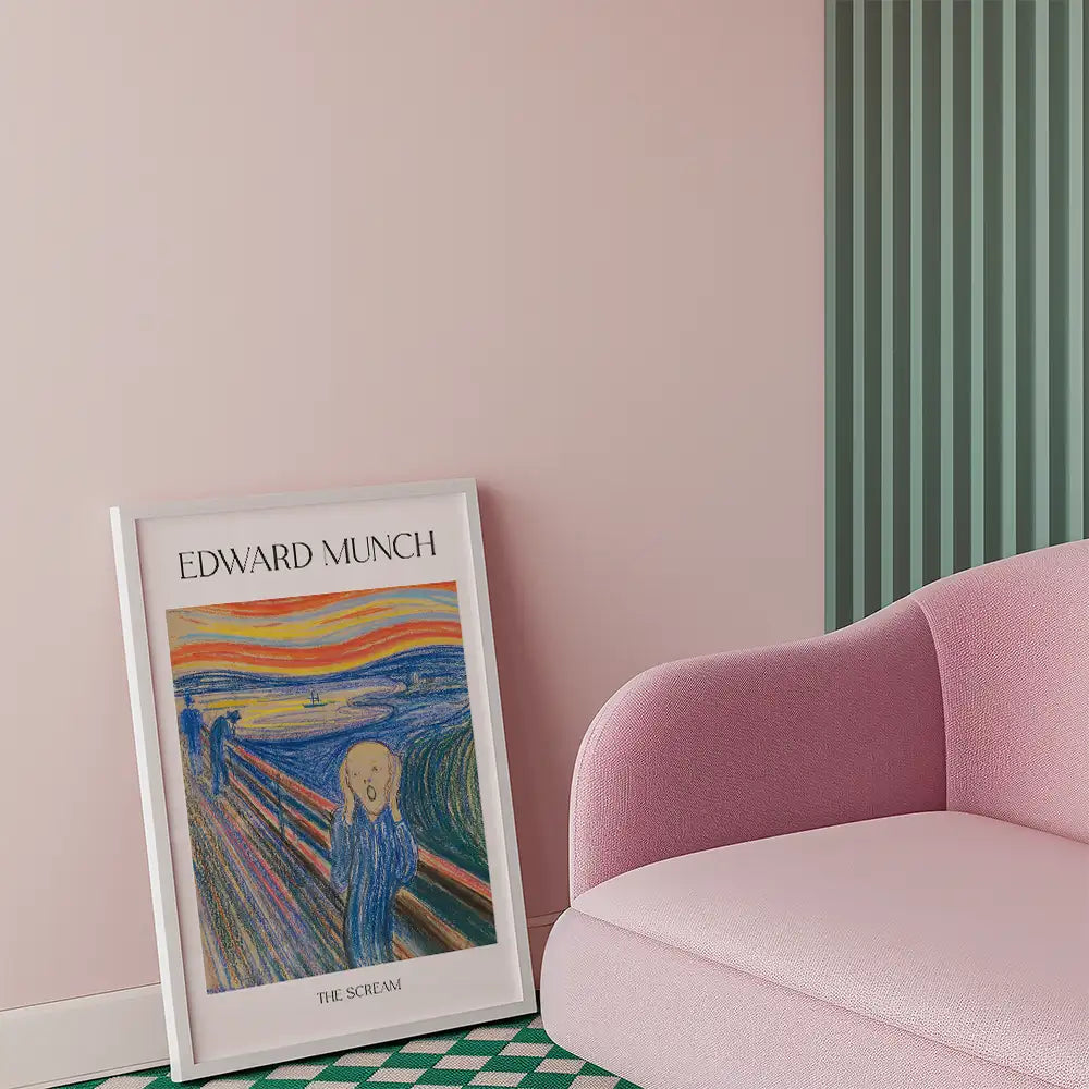 Framed poster of Edward Munch's "The Scream" leaning against a pink wall with a pink sofa in the background.