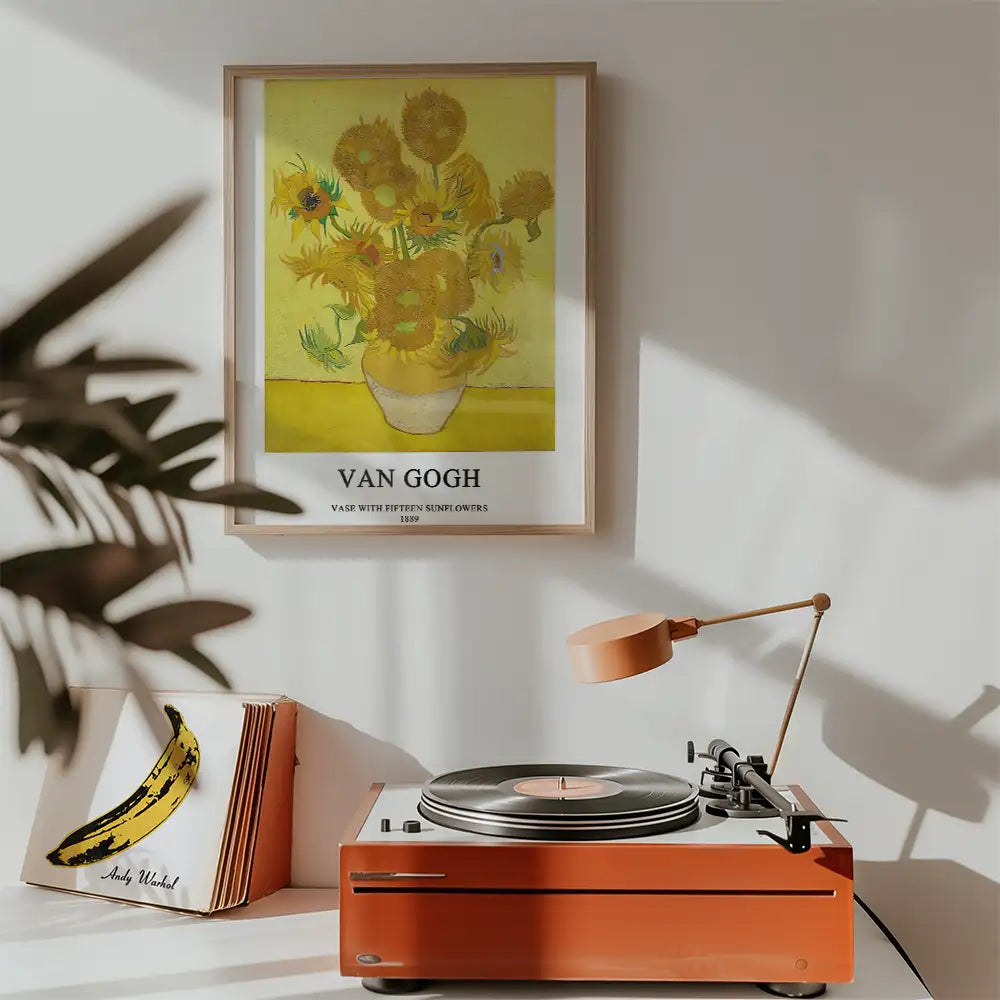 A framed Van Gogh poster featuring "Vase with Fifteen Sunflowers" alongside a vintage record player and a decorative banana artwork.